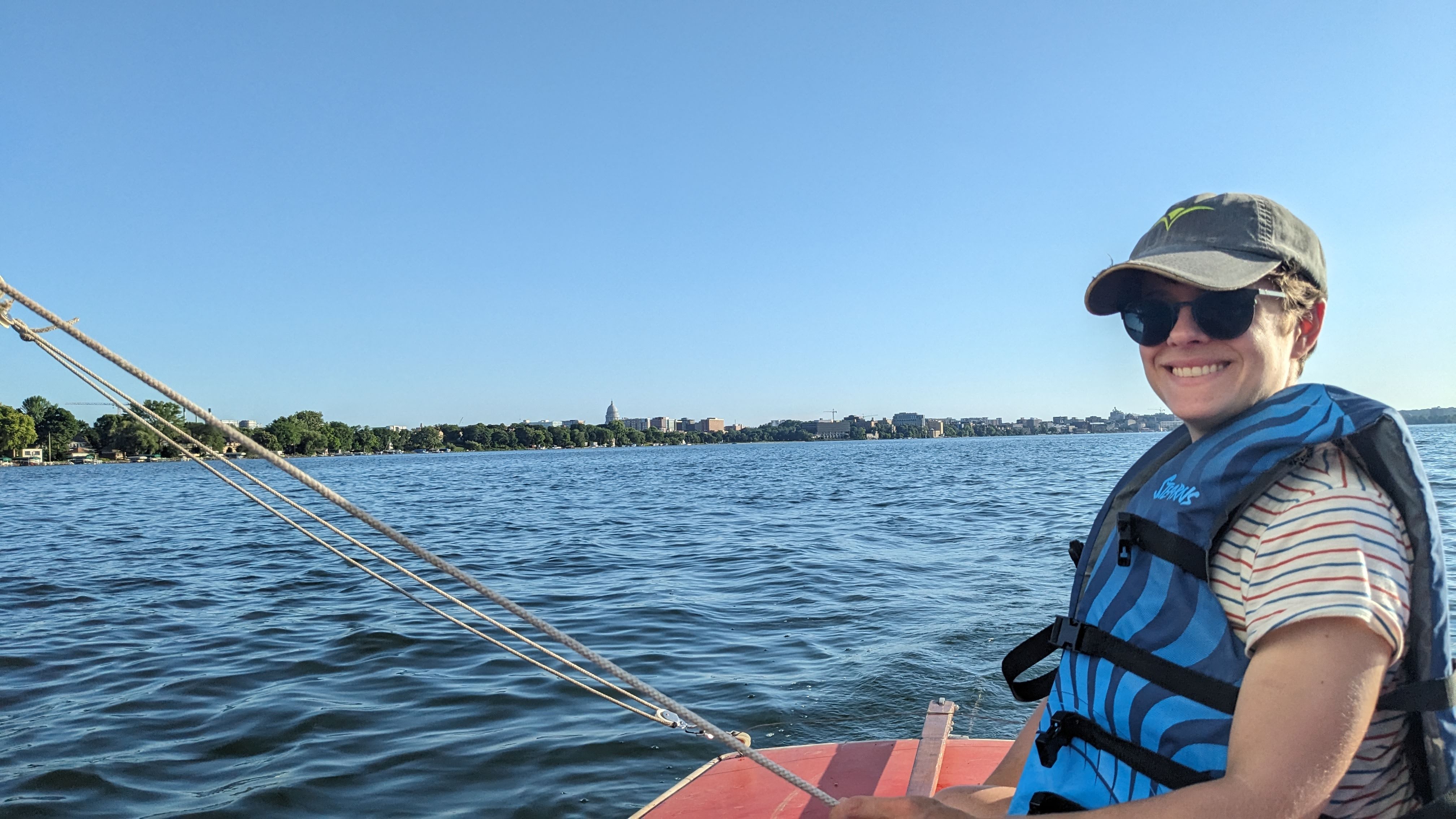 Claire sailing with the capitol in the background at the edge of a pretty blue lake